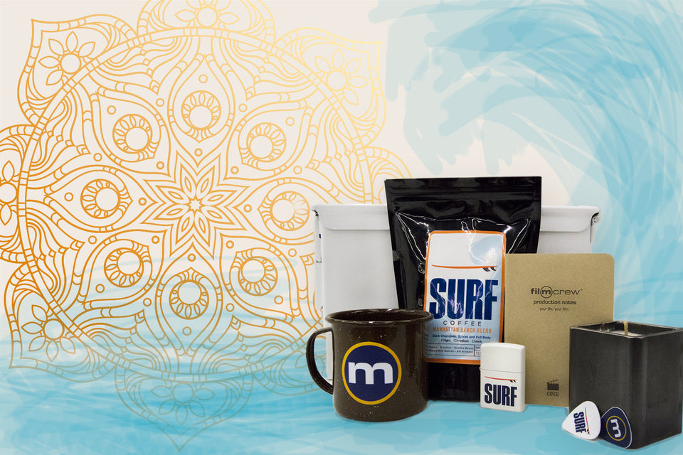 A grouping of some of our products: Surf coffee, coffee mug with letter m, notebook, candle, guitar pick and lighter.
